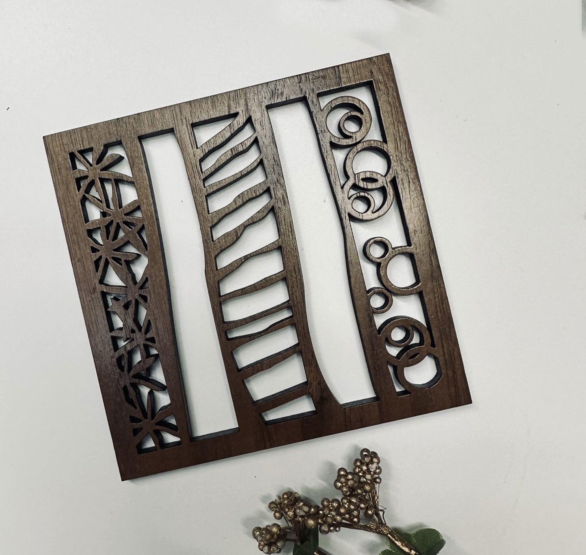 Decorative wooden coaster with geometric cutouts on a white background