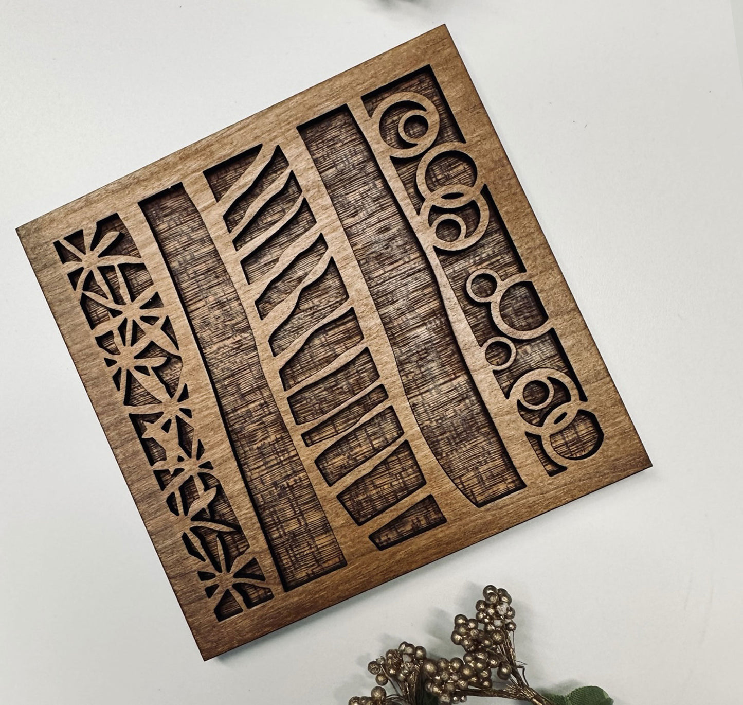 Wooden decorative coaster with geometric cutouts on a white background