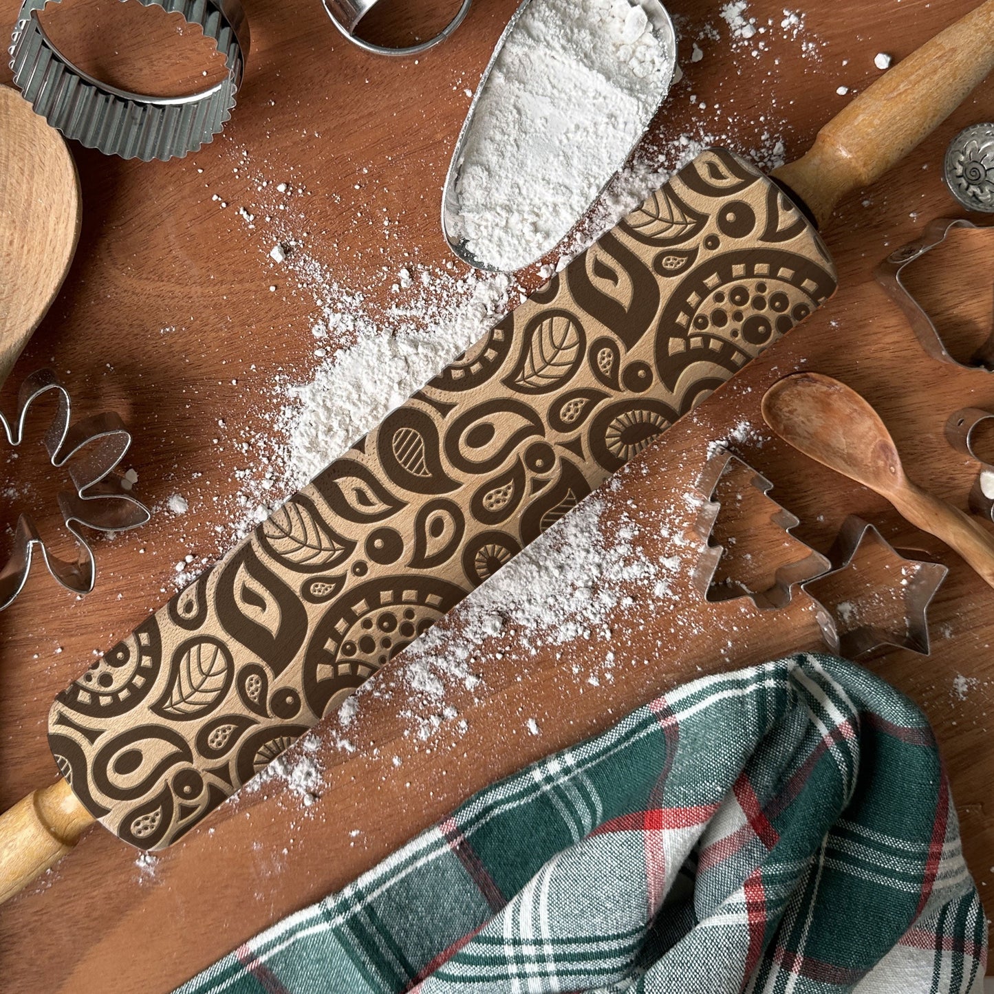 Patterned rolling pin with baking tools on a wooden surface