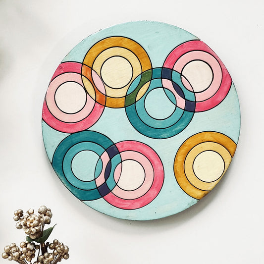 Decorative coaster with colorful circular design on a light blue background