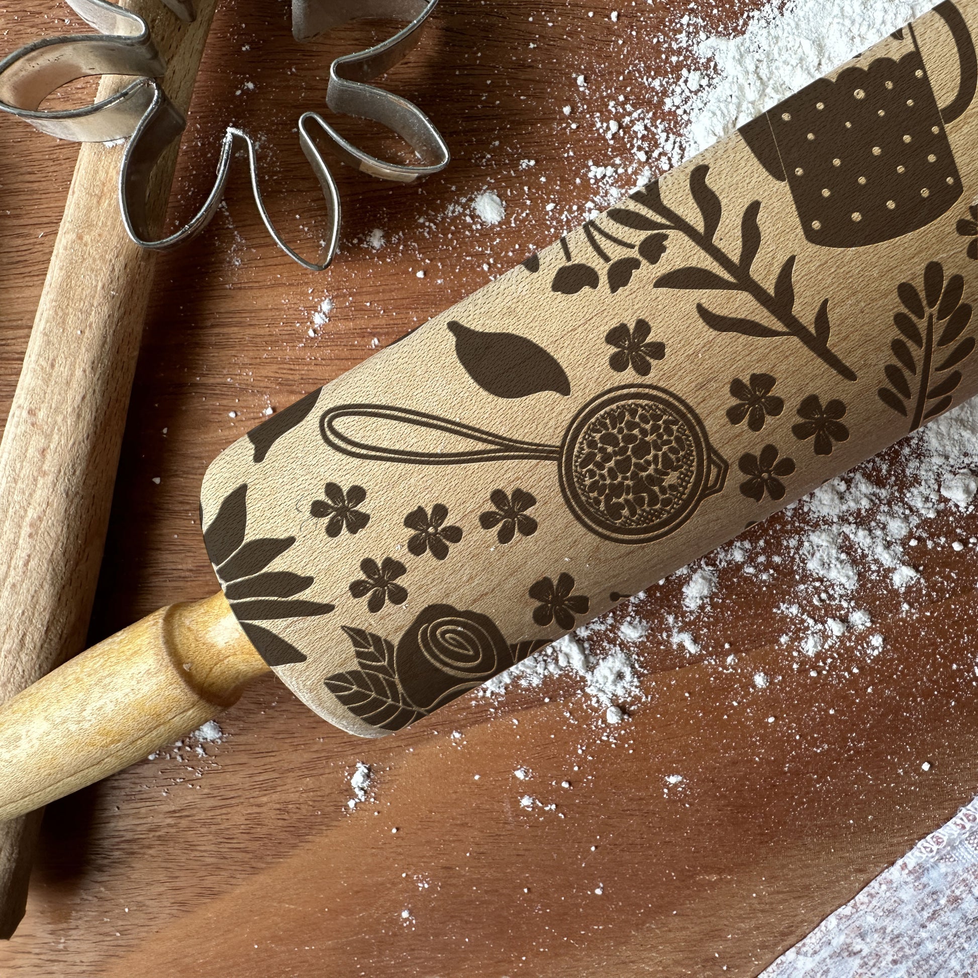 Wooden rolling pin with embossed designs on a wooden surface with flour.