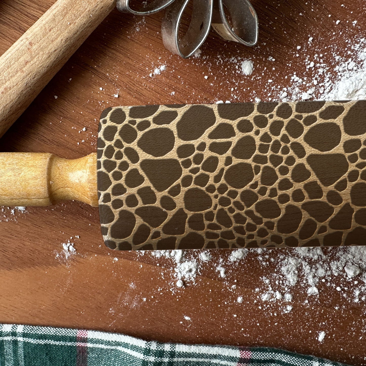 Rolling pin with a textured pattern on a wooden surface with flour.