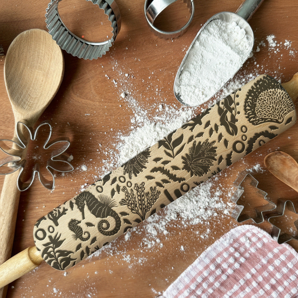 Decorative rolling pin with floral patterns on a wooden surface with flour and baking tools.
