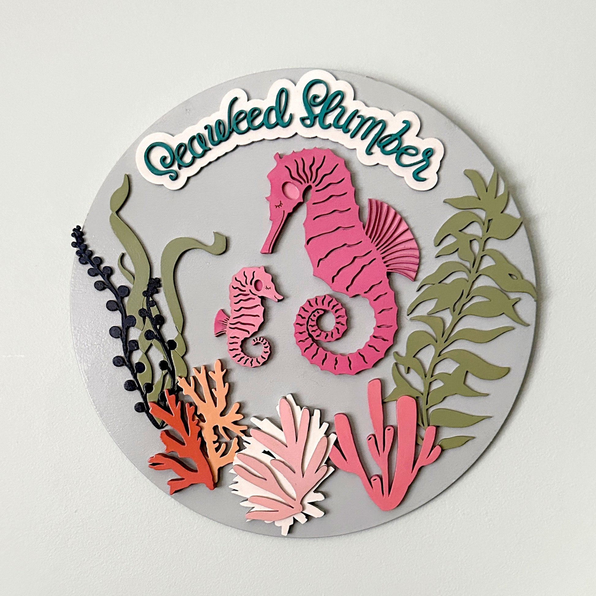 Decorative round coaster with sea-themed design and 'Gardened Glimmer' branding on a light gray background.