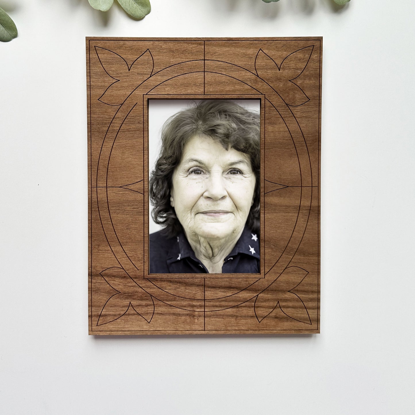 Wooden picture frame with a portrait of an elderly woman on a white background