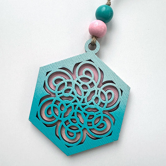 Decorative turquoise hanging ornament with pink and blue beads on a white background