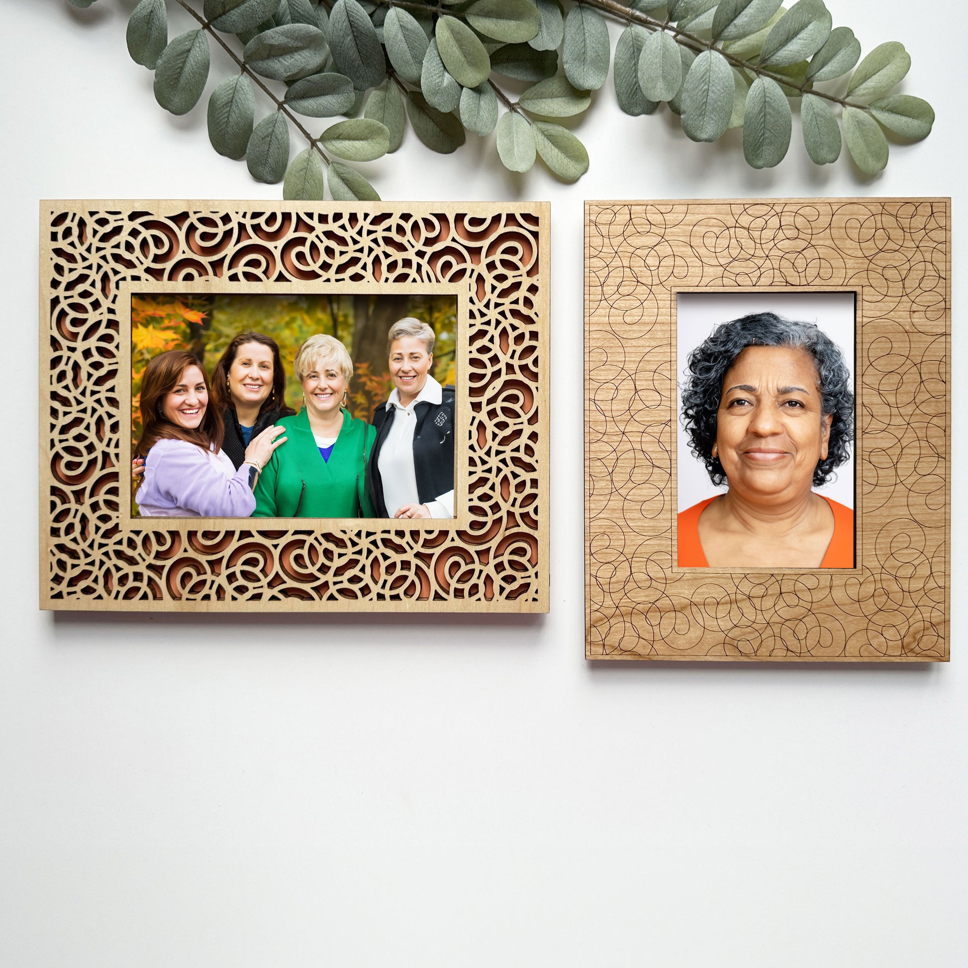 Two wooden photo frames with decorative patterns, one containing a family photo and the other a portrait of a woman.