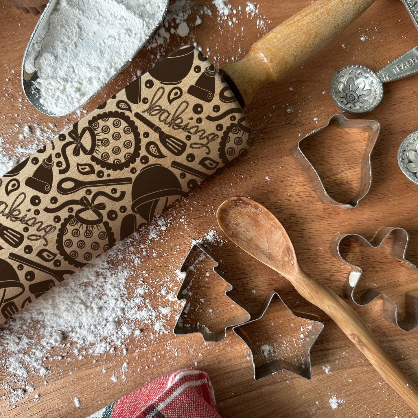 Wooden baking tools with flour, including a rolling pin, cookie cutters, and embossing stamps on a wooden surface.