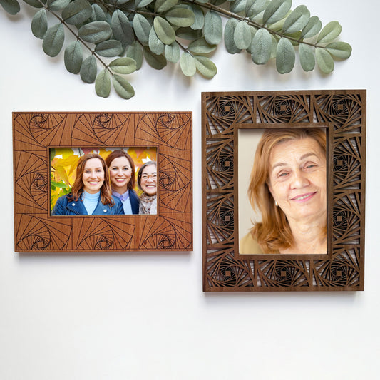 Two wooden picture frames with decorative patterns, one containing a family photo and the other a portrait of an older woman.