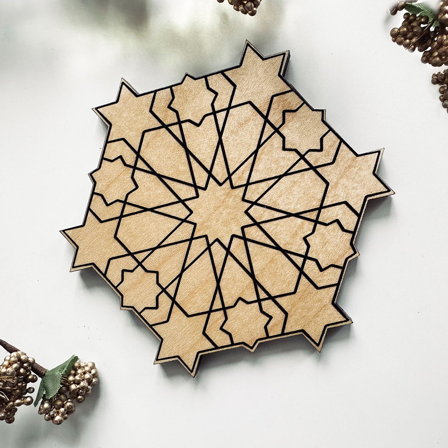 Geometric wooden coaster with star patterns on a light background