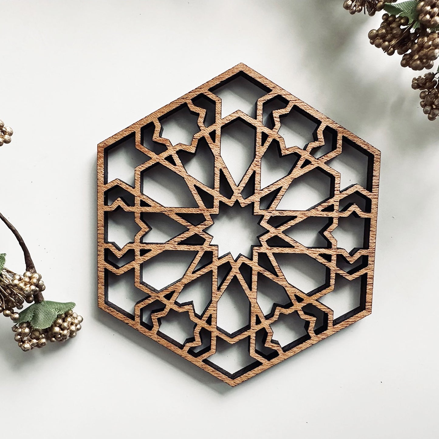 Decorative wooden coaster with geometric pattern on a white background