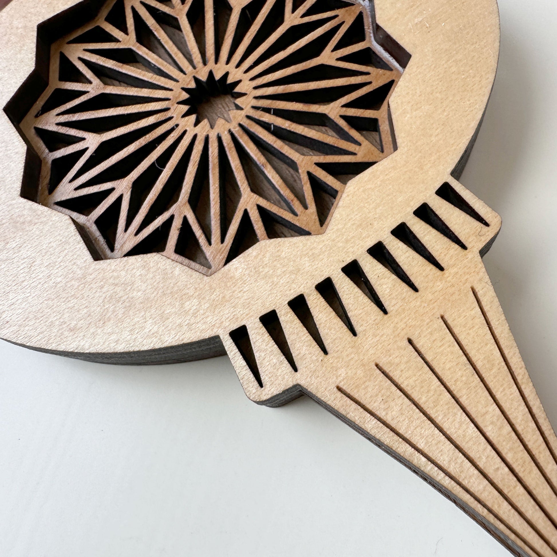 Wooden comb with geometric pattern on a light gray background