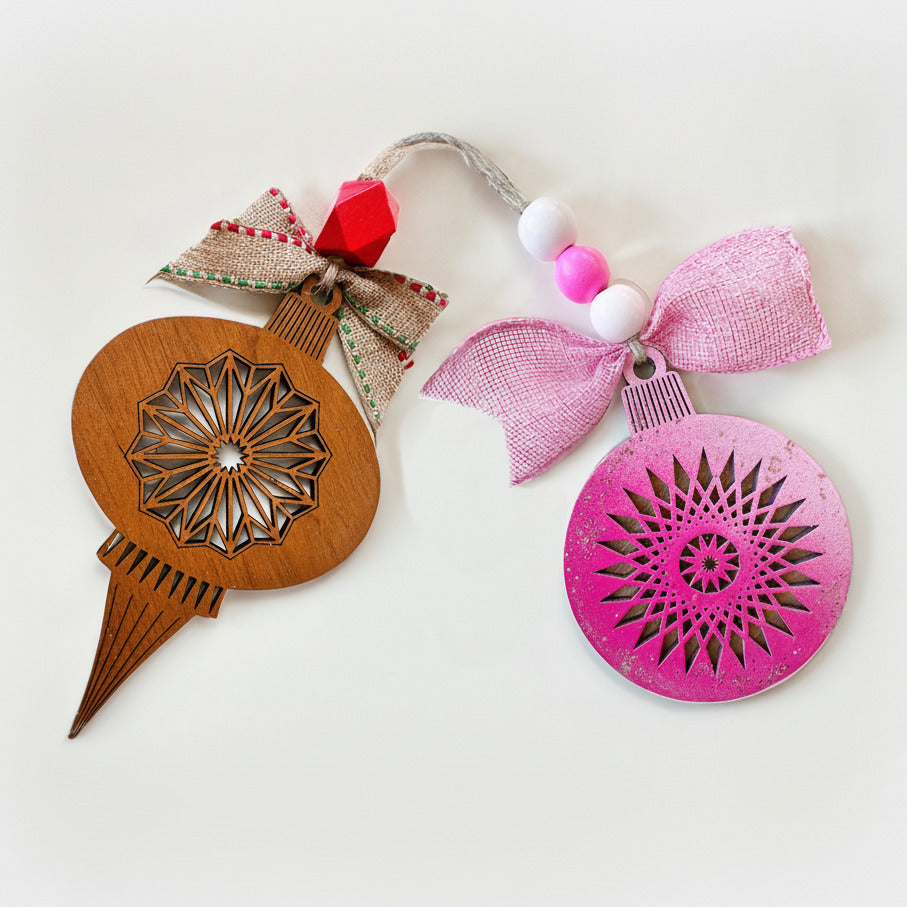 Two decorative ornaments, one wooden and one pink, on a white background.