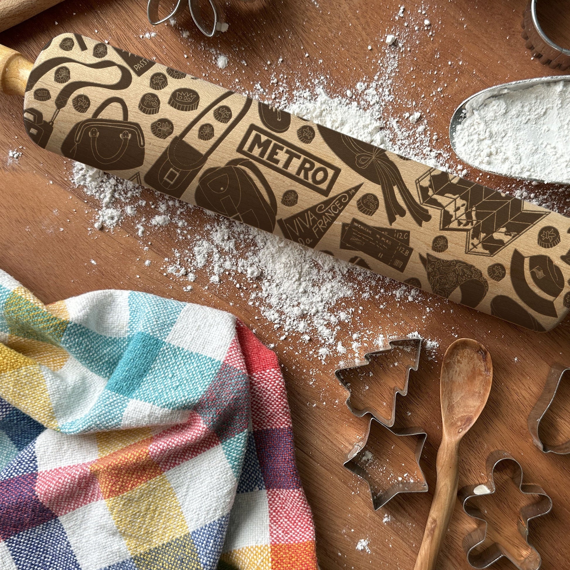 Decorative rolling pin with 'Metro' branding on a wooden surface with baking tools and flour.