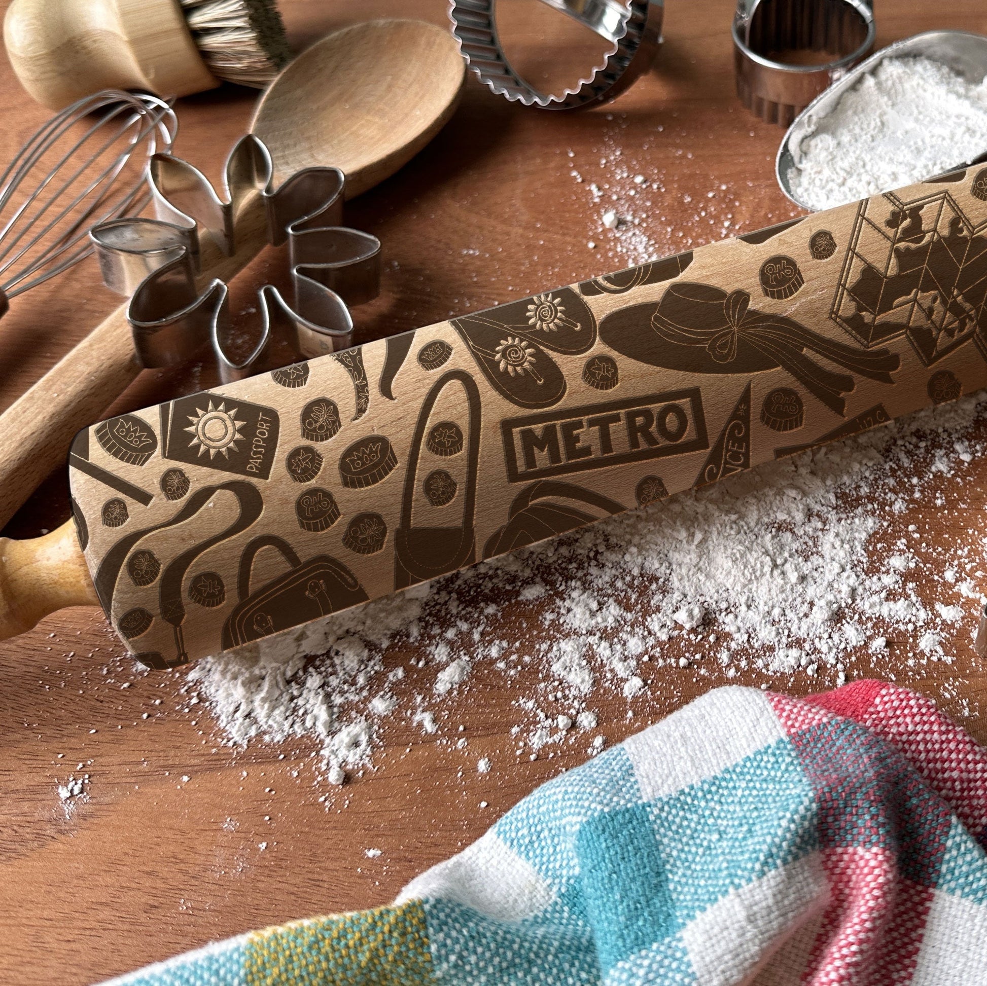 Decorative rolling pin with 'Metro' branding on a wooden surface with baking tools.