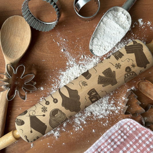 Wooden rolling pin with cookie cutters and flour on a wooden surface